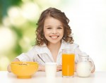 dívka s mlékem a ovocnou šťávou u snídaně k článku s recepty o probiotikach