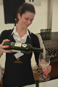 dívka rozlévá víno do sklenice na scéně Znojemského vinobraní