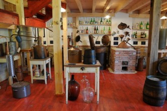 Na obrázku expozice muzea pálenic plná pálenek a destilačních přístrojů