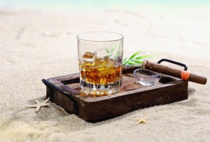 sklenice rumu a doutník na pláži Dominikánské republiky